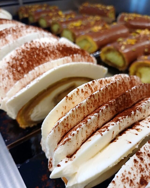 Tiramisu în tavă, feliat și pudrat cu cacao