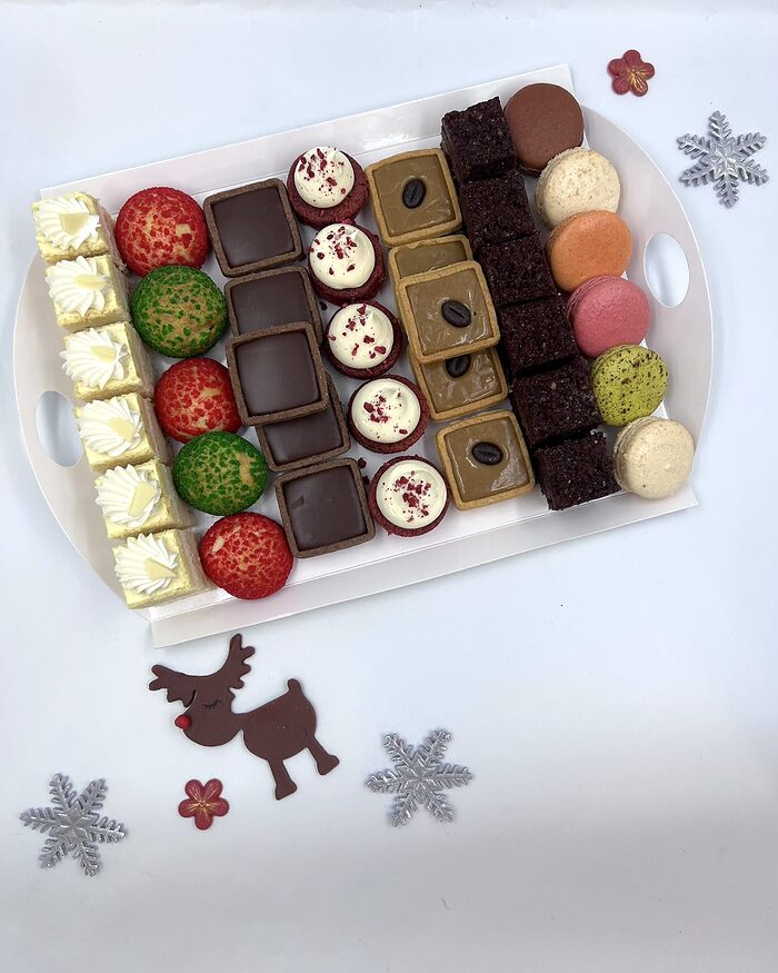 Platou asortat cu prăjituri mici, bomboane de ciocolată și macarons
