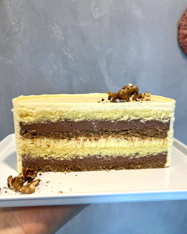 Secțiune de tort cu blat de nucă, mousse de ciocolată și cremă de vanilie
