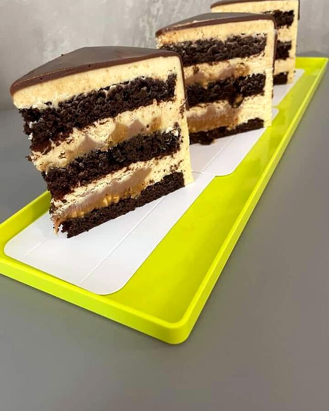 Secțiune de tort cu blat de cacao, cremă albă și glazură de ciocolată