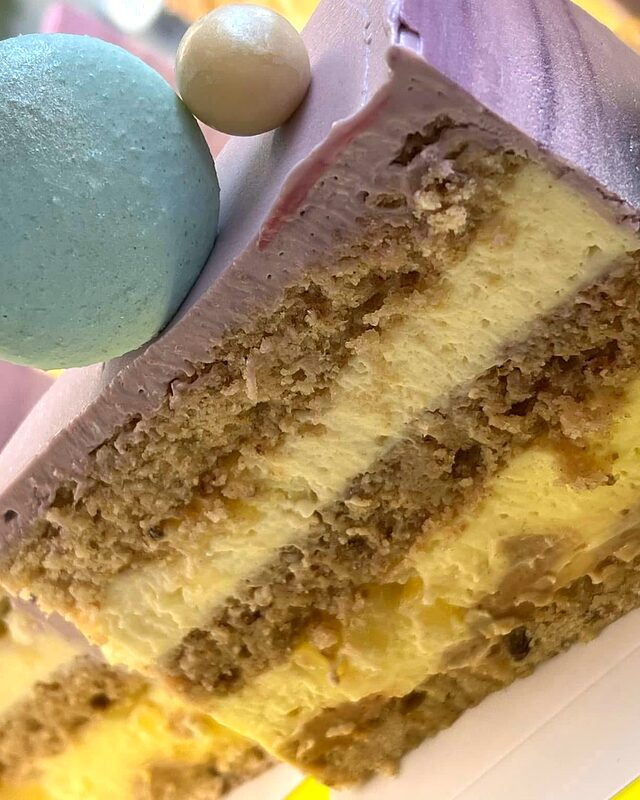 Secțiune de tort cu blat de fistic și cremă, decorat cu macarons
